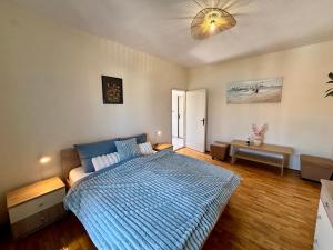 a bedroom with a bed with a blue comforter at ThePAGHouse in Pag
