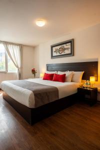 a bedroom with a large bed with red pillows at Hoteles Riviera Ejecutivo in Arequipa