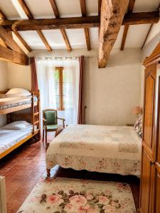 a bedroom with two bunk beds and a chair at Les Chambres Cast'elles in Malves