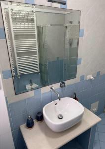 a bathroom with a white sink and a mirror at Appartamento ELDORADO in Lido di Pomposa +28 photos