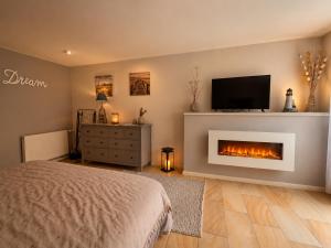 a bedroom with a fireplace with a tv and a bed at Ferienwohnungen Stilschön in Warnemünde