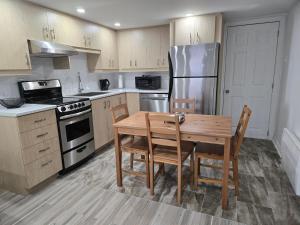 a kitchen with a table and chairs and a refrigerator at Private Entry-Modern & Bright Longueuil Suite in Longueuil