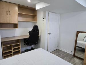 a bedroom with a desk and a chair and a bed at Private Entry-Modern & Bright Longueuil Suite in Longueuil