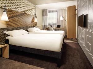 a hotel room with a large bed and a desk at ibis London Excel-Docklands in London