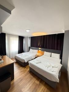 a hotel room with two beds and a desk at Hotel Otağ in Istanbul +80 photos