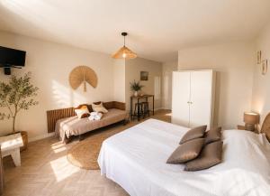 a bedroom with two beds and a couch at Hôtel La Coursive Oléron in Saint-Pierre-dʼOléron