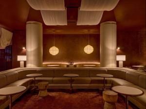 a waiting room with a couch and tables and lights at Sofitel Sydney Wentworth in Sydney