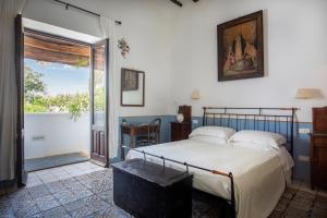 a bedroom with a bed and a door to a balcony at Boutique Hotel I Cinque Balconi in Santa Marina Salina +104 photos
