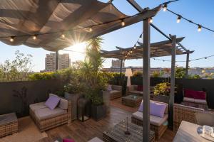 eine Dachterrasse mit Stühlen und einem Sonnenschirm in der Unterkunft Warmthotel in Rom