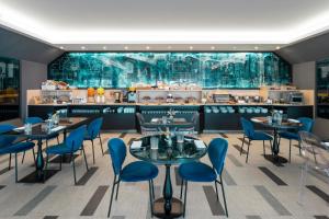 Ein Restaurant mit Tischen und Stühlen vor einer Theke in der Unterkunft Warmthotel in Rom