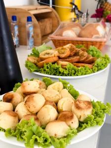 two plates of food on a table with lettuce at Hotel Glória in Piranhas