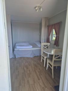 a small room with a bed and a table and chairs at Utsikten Bjerkøya - Where the View Meets the Sea, app 1h from Oslo in Holmestrand