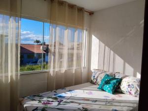 a bed in a room with a window at Triplex com linda vista para o mar de Parati Anchieta ES in Anchieta