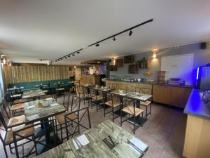 a restaurant with tables and chairs and a bar at Hôtel des Argousiers in Ambleteuse