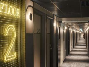 a hallway of a building with a neon sign on it at Ibis Warszawa Stare Miasto in Warsaw