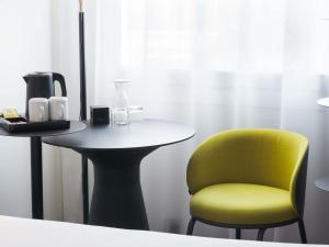 a yellow chair sitting next to a small table with a yellow chair at Ibis Warszawa Stare Miasto in Warsaw +39 photos