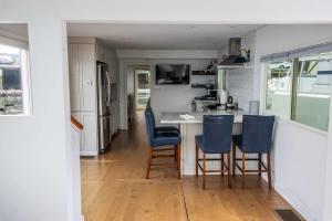 a kitchen with blue chairs and a kitchen island at Endless Summer Oceanside Views in Boston