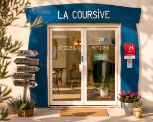 a blue storefront with signs in front of a restaurant at Hôtel La Coursive Oléron in Saint-Pierre-dʼOléron