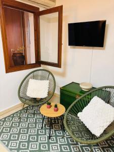two chairs and a table in a room with a tv at Ca Isaak in Denia
