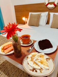 a table with plates of food on a bed at Pousada Casa da Adriana in Fortaleza