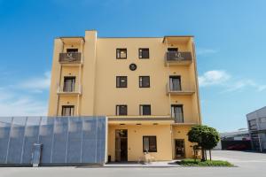 a tall yellow building with a clock on it at ML Business Hotel - Self-Check-in in Lannach