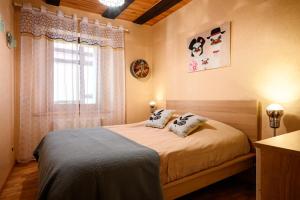 a bedroom with a bed with two pillows and a window at Gîte Le Nain Rouge in Kaysersberg