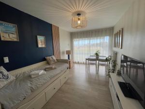 a living room with a couch and a dining room at Studio face mer L'escapade marine in Calais