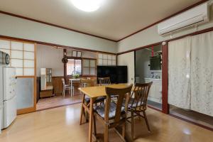 a kitchen and dining room with a table and chairs at ゲストハウス五郎平 in Nagahama
