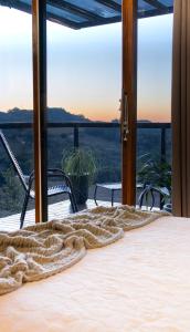 a bed in a room with a view of the ocean at Cabana Altavista in Flores da Cunha