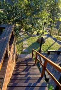 a wooden stairway with a wooden fence and a tree at Cabana Altavista in Flores da Cunha