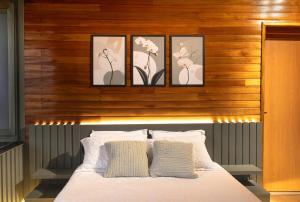 a bedroom with a bed with four pictures above it at Cabana Altavista in Flores da Cunha