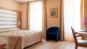 a bedroom with a bed and a blue chair at Hotel Vela d'Oro Dependence in Bardolino +11 photos