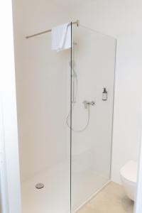 a white bathroom with a glass shower stall at ML Business Hotel - Self-Check-in in Lannach