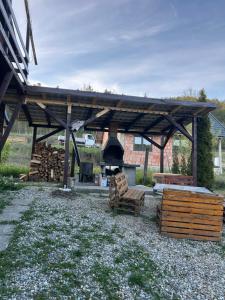 a wooden pavilion with a pile of logs and benches at Cabana Bubu in Dej