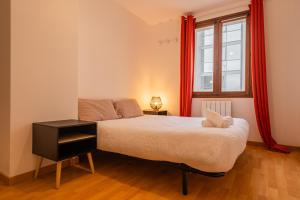 a bedroom with a bed and a window with red curtains at Villa Paradis - Grande demeure familiale proche Puy-du-Foυ in Cholet