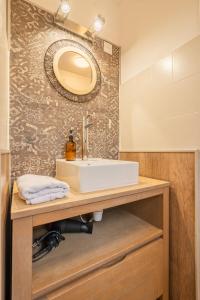 a bathroom with a sink and a mirror at Villa Paradis - Grande demeure familiale proche Puy-du-Foυ in Cholet