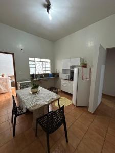 a kitchen with a table and chairs and a refrigerator at Apartamento 2 quarto e garagem G para 2 carro in Rio Verde