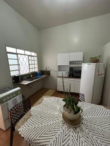 a kitchen with a table with a potted plant on it at Apartamento 2 quarto e garagem G para 2 carro in Rio Verde +9 photos