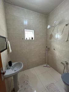 a white bathroom with a sink and a shower at Apartamento 2 quarto e garagem G para 2 carro in Rio Verde