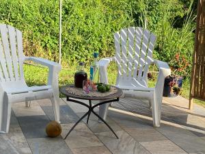 two white chairs and a table with fruit on it at La Marlyse in La Vatable