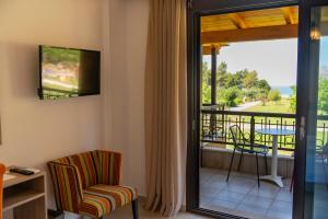 a room with a balcony with a table and chairs at Riviera Perdika Hotel in Perdika