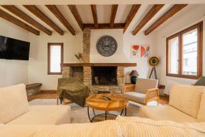 a living room with a fireplace and a clock on the wall at Villa Paradis - Grande demeure familiale proche Puy-du-Foυ in Cholet
