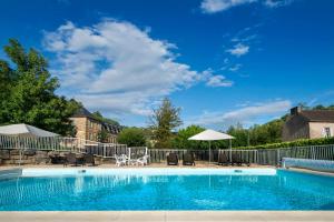 a swimming pool with chairs and an umbrella at Village Vacances L'Oustal in Salles-la-Source