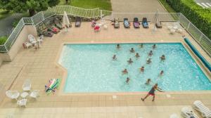 a group of people in a swimming pool at Village Vacances L'Oustal in Salles-la-Source +17 photos