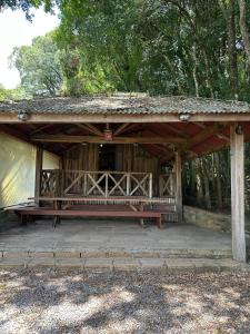 a wooden pavilion with a bench in the woods at Rancho Cantinella in Garibaldi