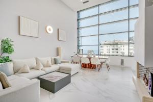 a white living room with a white couch and a table at Penthouse Duplex with TOP Views! in Barcelona