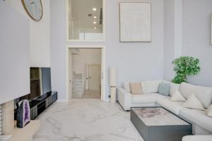 a living room with white furniture and a tv at Penthouse Duplex with TOP Views! in Barcelona +56 photos