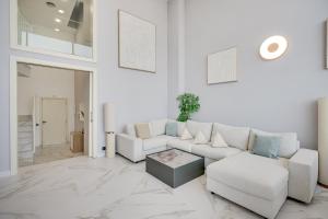 a white living room with a couch and a table at Penthouse Duplex with TOP Views! in Barcelona