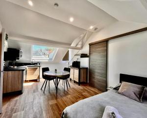 a bedroom with a bed and a table and a kitchen at La Villa l'Oiseau Bleu proche de la plage et de Deauville !!! Awards 2025 in Blonville-sur-Mer