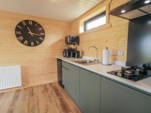 a kitchen with a large clock on the wall at Alken The Stag in Bushmills